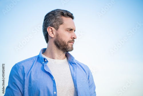pensive man portrait standing peaceful. pensive man in shirt outdoor. pensive man on sky background