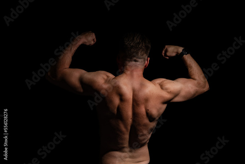 Sexy portrait of muscular handsome topless male isolated against a grey background
