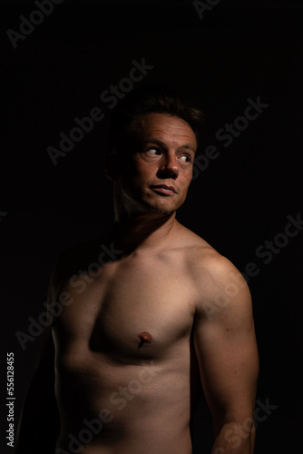 Sexy portrait of muscular handsome topless male isolated against a black background © Collins Photography