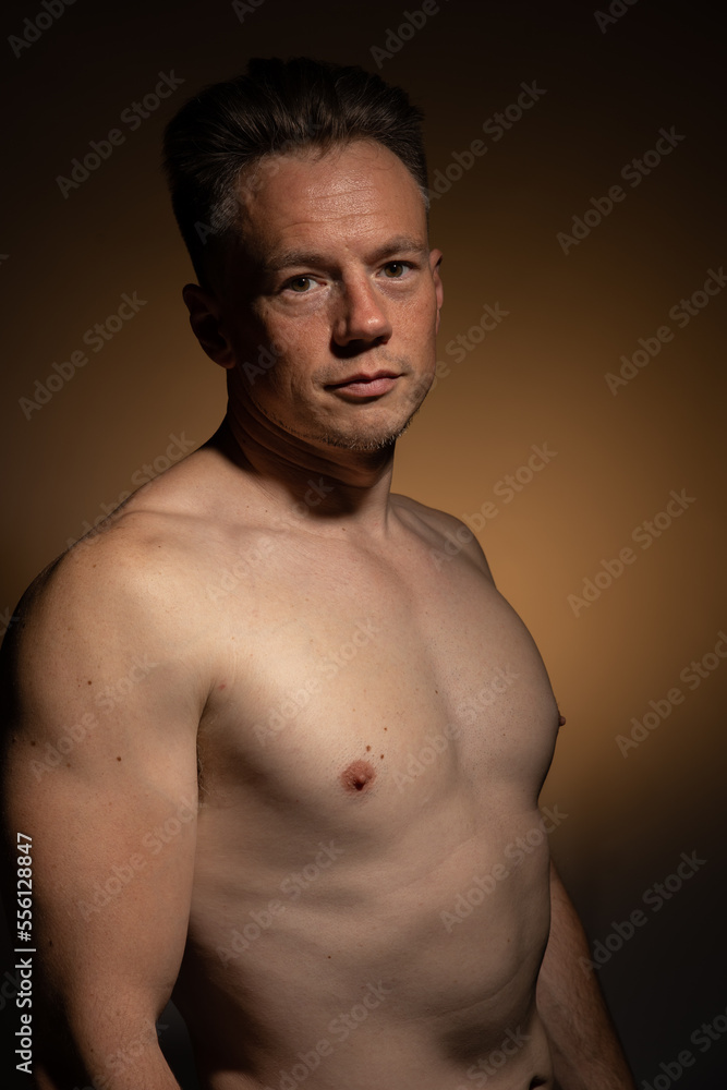Sexy portrait of muscular handsome topless male isolated against a coloured background Sexy portrait of muscular handsome topless male isolated against a coloured background
