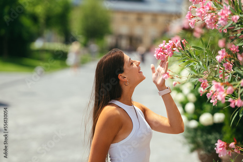 Outdoor portrait of young beautiful lady posing near flowering tree.