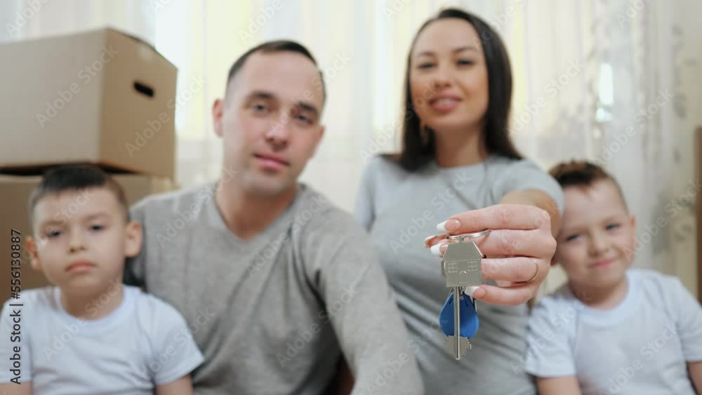 Amused family enjoys moving together into new apartment and holds key. Excited parents and boy children get ready for arrangement in own property Amused family enjoys moving together into new apartment and holds key. Excited parents and boy children get ready for arrangement in own property