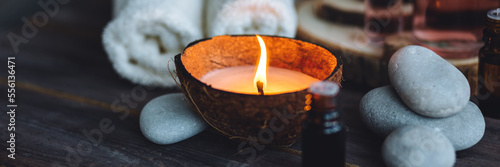 Concept of natural essential organic oils, Bali spa, beauty treatment, relax time. Atmosphere of relaxation, pleasure. Candles, towels, dark wooden background. Alternative oriental medicine. Banner