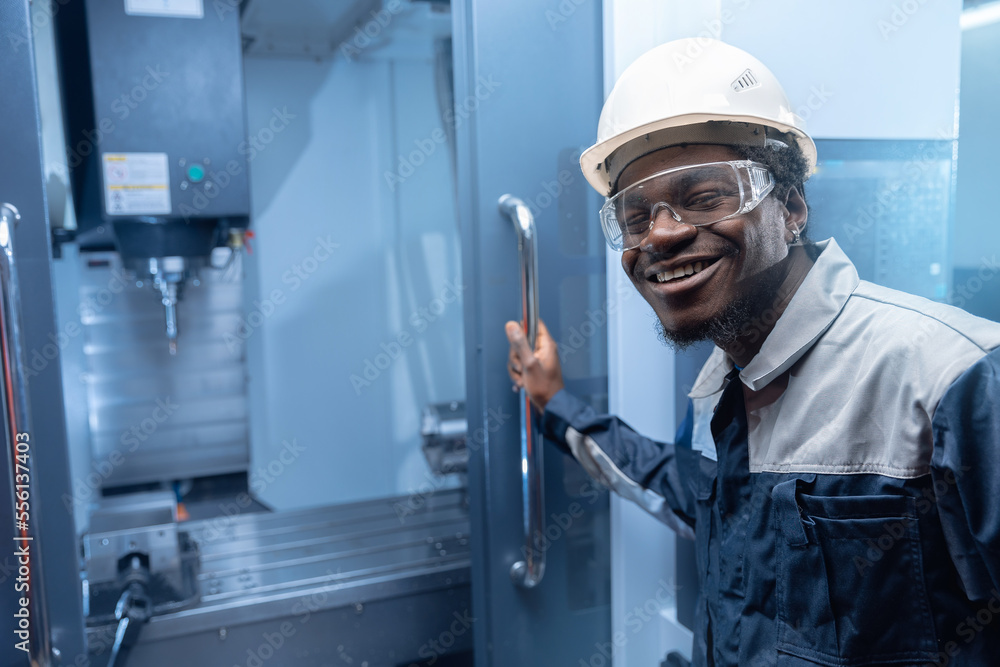 Professional african american engineer man in helmet uniform use CNC machinery, blue toning. Concept banner industry factory people Professional african american engineer man in helmet uniform use CNC machinery, blue toning. Concept banner industry factory people