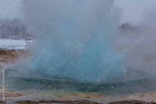 Geyser in fase iniziale di eruzione mentre si sta creando la bolla azzurra durante una nevicata photo