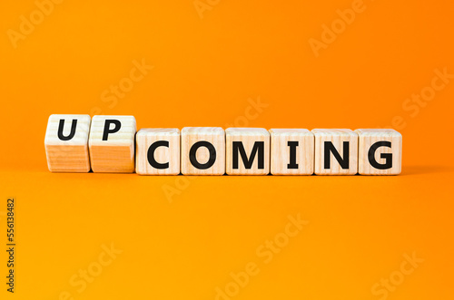 Coming or upcoming symbol. Concept words Coming and Upcoming on wooden cubes. Beautiful orange table orange background. Business coming or upcoming concept. Copy space.