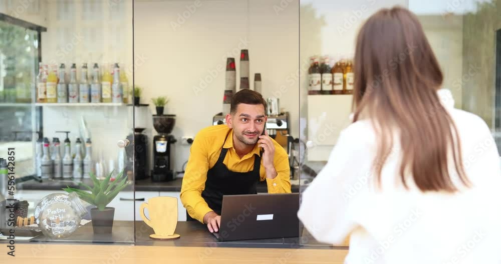 Young working man who is busy and at the same time a client comes to him, a lady in a white coat. Young working man who is busy and at the same time a client comes to him, a lady in a white coat.