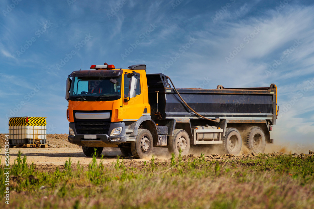 Tipper Truck driving on a sandy road kicking up dust and sand Tipper Truck driving on a sandy road kicking up dust and sand