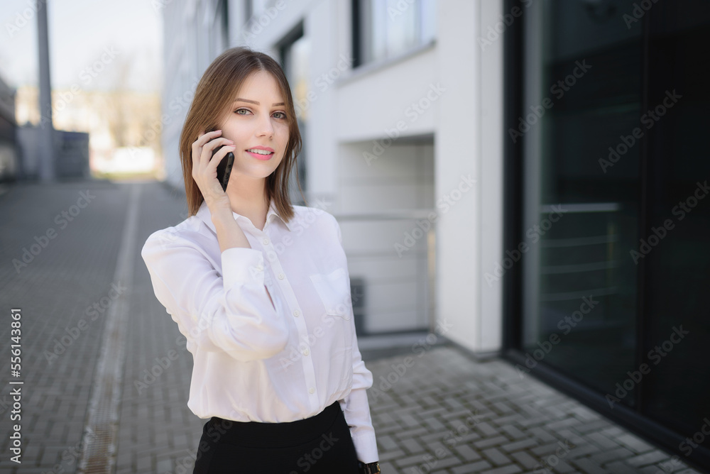 Young business woman talking on the phone and looking straight ahead.Concept communication . Young business woman talking on the phone and looking straight ahead.Concept communication .