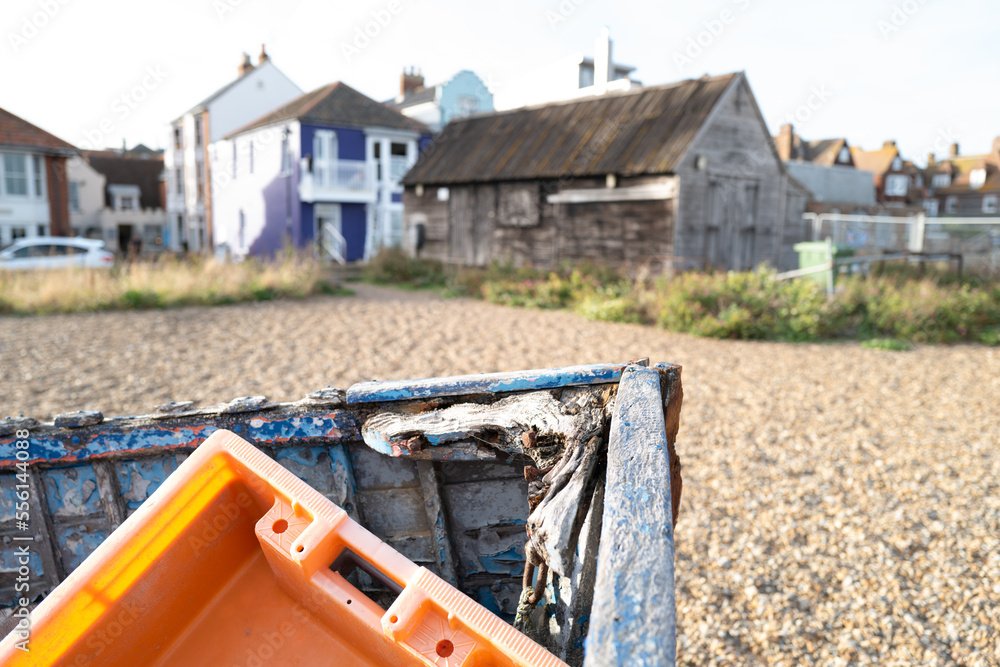 Shallow focus of an orange, plastic crate seen discarded in a on wooden boat. Located on the Suffolk coast.