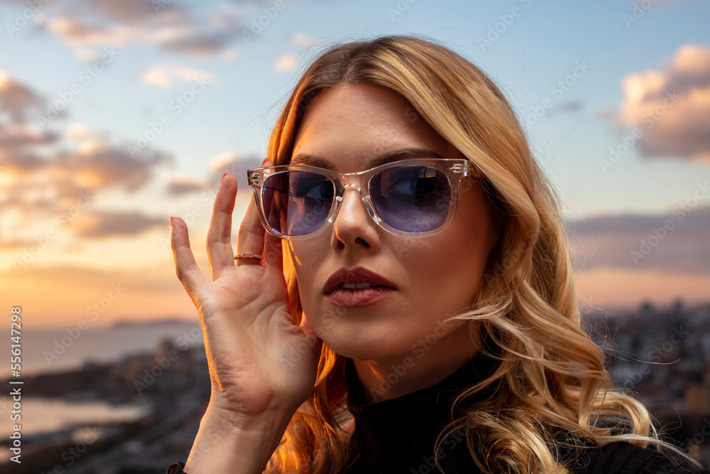 Beautiful female model wearing colorful glasses at sunset. Outdoors romantic portrait of attractive blonde woman with makeup and glasses posing. Istanbul archipelago (Princess Islands) skyline. Beautiful female model wearing colorful glasses at sunset. Outdoors romantic portrait of attractive blonde woman with makeup and glasses posing. Istanbul archipelago (Princess Islands) skyline.