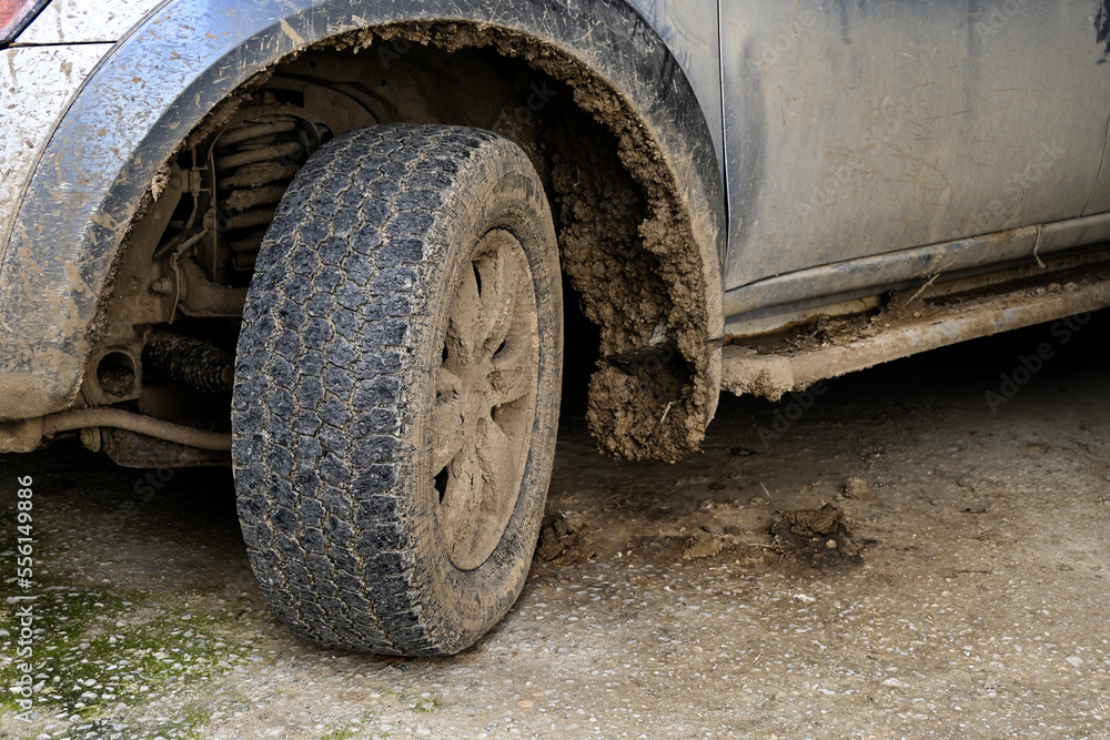 closeup of a muddy tire and dirty car