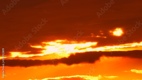 Clouds set at red yellow and orange sky. Hot summer atmosphere at heat wave. Yellow setting at epic golden hour time lapse.