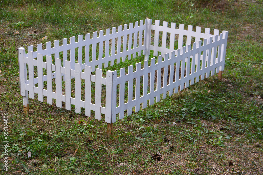 white wooden fence on the lawn isolated, close-up white wooden fence on the lawn isolated, close-up