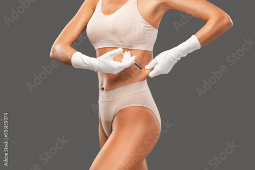 Lipolytic injections to burn fat on the stomach, legs and waist of a woman. Female aesthetic cosmetology in a beauty salon.Cosmetology concept.