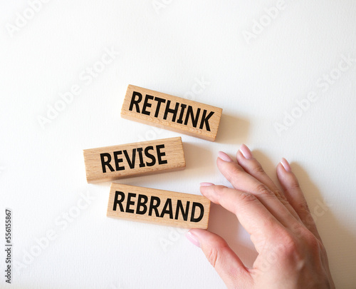 Rethink Revise Rebrand symbol. Wooden blocks with words Rethink Revise Rebrand. Beautiful white background. Businessman hand. Business and Rethink Revise Rebrand concept. Copy space.