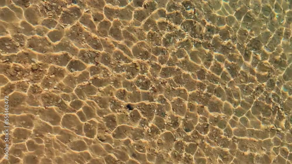 Background of crystal clear water. Close-up of sea water with light reflections. Natural texture top view. Bright sun glare on the surface of the water. Red sea with ripples on a sunny day. Egypt Background of crystal clear water. Close-up of sea water with light reflections. Natural texture top view. Bright sun glare on the surface of the water. Red sea with ripples on a sunny day. Egypt