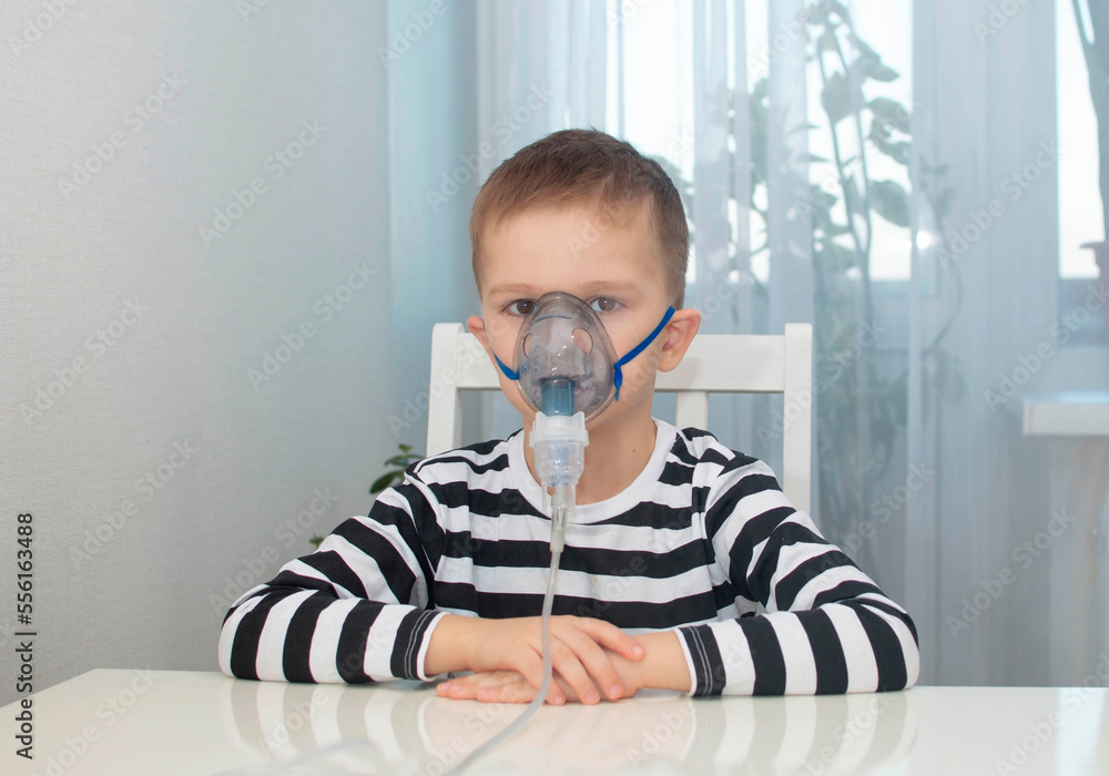 Boy is holding an inhaler and breathing. He was filmed for articles