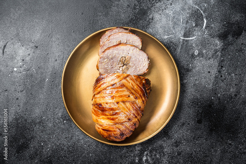 Roasted bacon wrapped meatloaf, sliced mince meat loaf. Black background. Top view photo