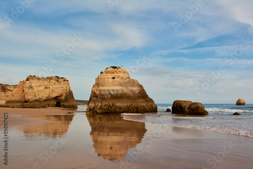Symmetrical reflection of the limestone rocks in the water of low tide. Praia dos Tres Castelos, Portimao