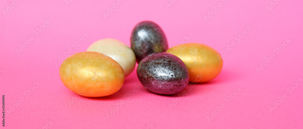 Chocolate eggs on a pink background for Easter. The eggs are multicolored. Happy Easter. Chocolate. Sweets for children and adults. Candy. Dessert. Copy space. Top view. Flat lay. Banner Chocolate eggs on a pink background for Easter. The eggs are multicolored. Happy Easter. Chocolate. Sweets for children and adults. Candy. Dessert. Copy space. Top view. Flat lay. Banner