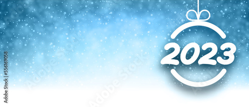 2023 sign in christmas bauble on blue snowing background.