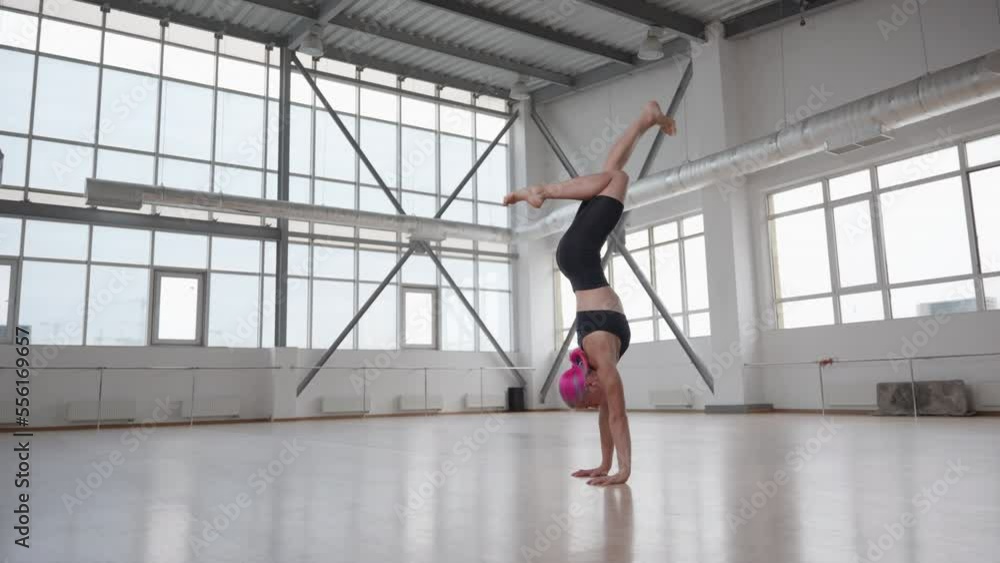 Caucasian girl with pink-colored hair doing a handstand. Active, young woman creating a balance in a freestanding scissor bail standing. High quality 4k footage Caucasian girl with pink-colored hair doing a handstand. Active, young woman creating a balance in a freestanding scissor bail standing. High quality 4k footage