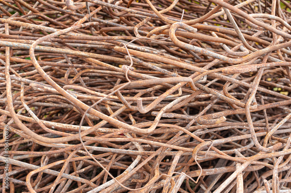 a frame filled with all-metal bent rebar in a warehouse of secondary ferrous metal for recycling. Metal processing, scrap metal remelting in metallurgy industry a frame filled with all-metal bent rebar in a warehouse of secondary ferrous metal for recycling. Metal processing, scrap metal remelting in metallurgy industry