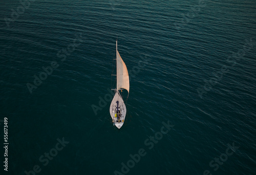 Yacht on blue water. View of the yacht in the open sea. Drone photo