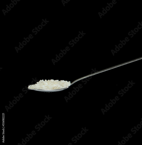 Japanese Rice fall, white grain rices pouring down abstract cloud fly from spoon. Beautiful complete seed rice in air, food object design. Selective focus freeze shot Black background isolated