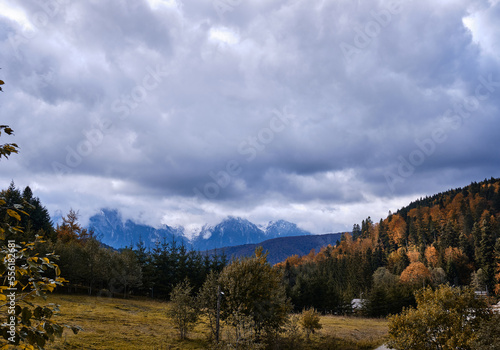 Autumn view of snowy mountains. Autumnal hills and snowy mountain ridge. Bucegi natural park
