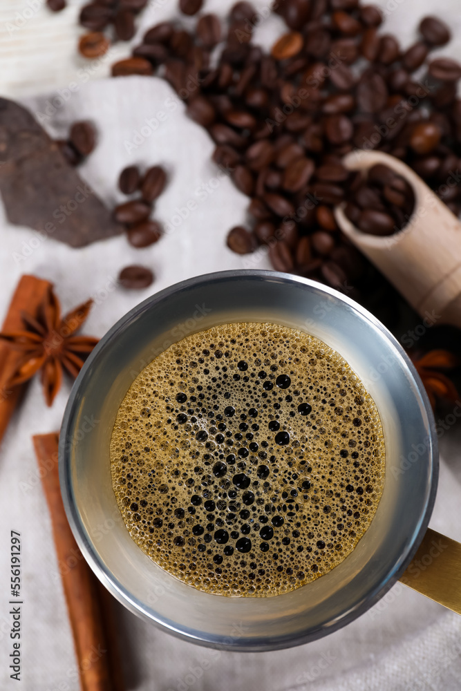 Turkish coffee pot with hot drink, beans and spices on table, flat lay. Space for text Turkish coffee pot with hot drink, beans and spices on table, flat lay. Space for text