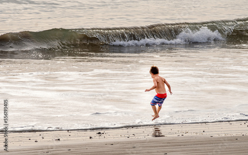 A young boy is enjoying the activities on the shore of Pacific ocean