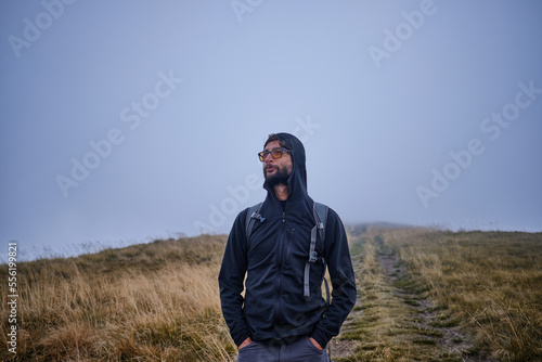 Man hiker hiking in mountain  autumn weather mountains wearing cold weather  Guy portrait lifestyle. © Ketrin