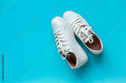 White classical leather shoes on blue background. Still life, modern shoes. minimalistic background  © Natali