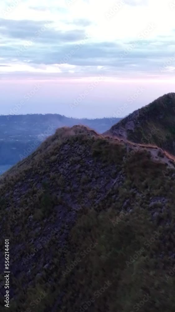 Vertical video of People standing on edge of volcano crater at sunrise Vertical video of People standing on edge of volcano crater at sunrise