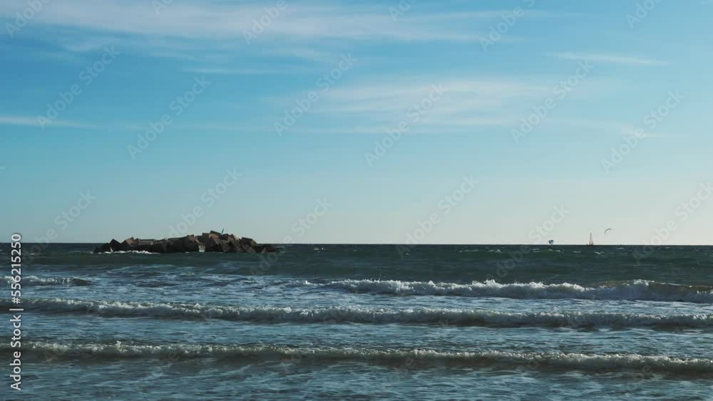 People windsurfing on huge waves at windy day. Young active persons kitesurfing People windsurfing on huge waves at windy day. Young active persons kitesurfing