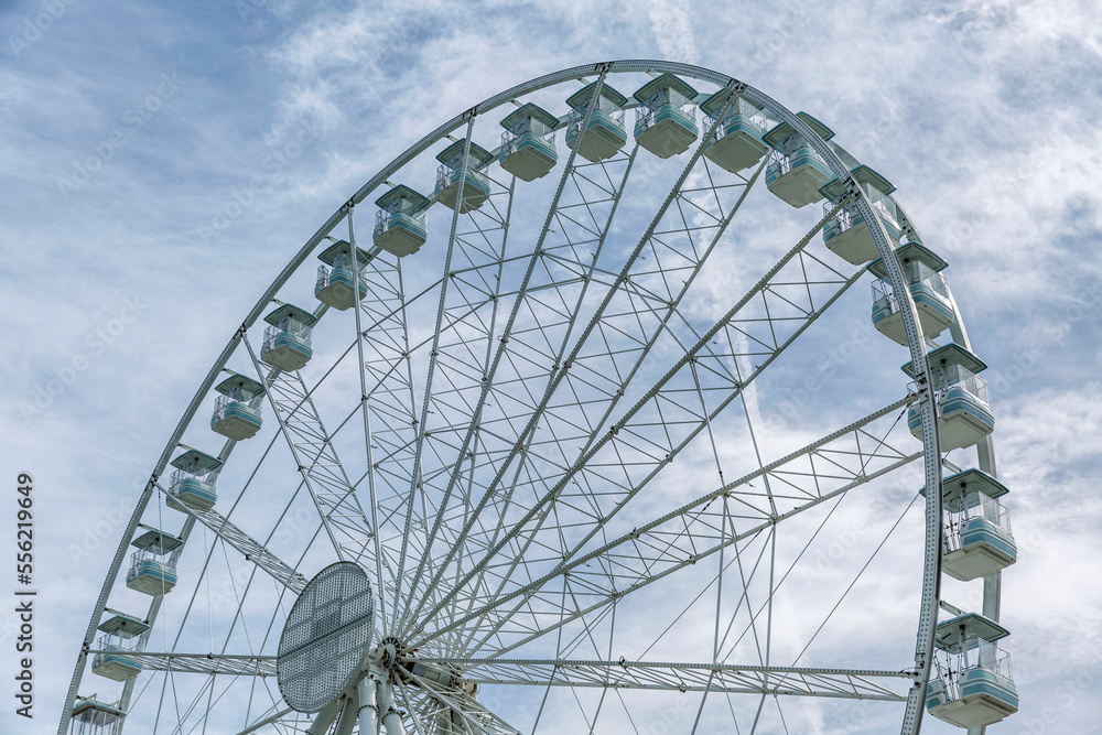 Ferris wheel on the background of a cloudy sky. Bottom view. Entertainment, active recreation and holidays. Close-up. Ferris wheel on the background of a cloudy sky. Bottom view. Entertainment, active recreation and holidays. Close-up.