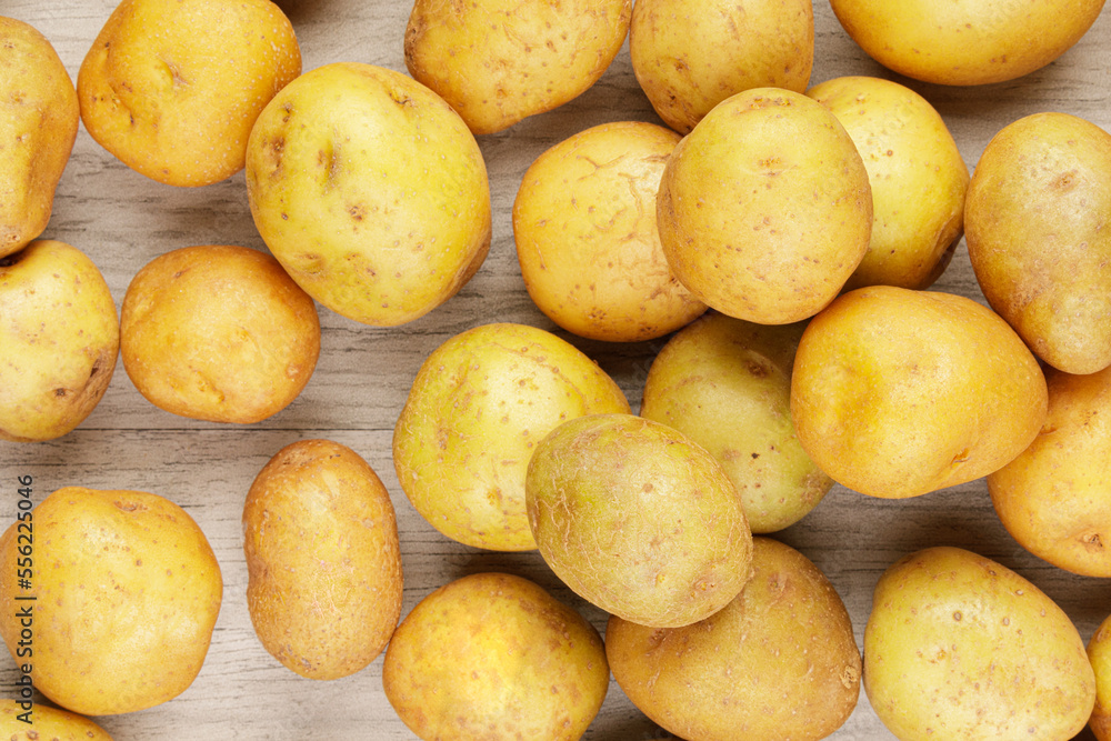 A background of New or Baby Potatoes on wooden table