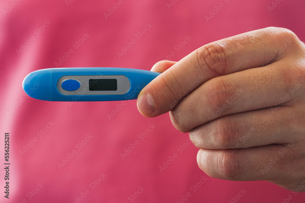 Close-up view of blue thermometer in male hand Close-up view of blue thermometer in male hand