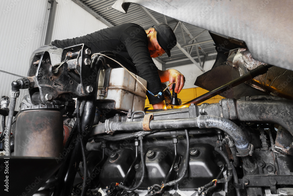 custom made wallpaper toronto digitalCar mechanic repairs large truck or tractor in workshop. Professional mechanic repairs truck engine. Genuine worker..