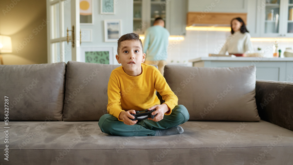 Boy kid playing video computer game at home living room Boy kid playing video computer game at home living room