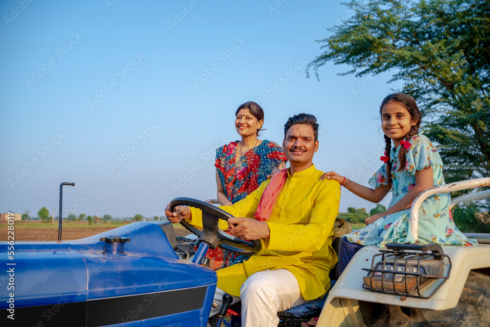 Indian farmer sitting on tractor with wife and little daughter. Indian ...