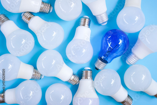 Top view of pile of white and blue light bulb on light blue background , unique and differentiation concept