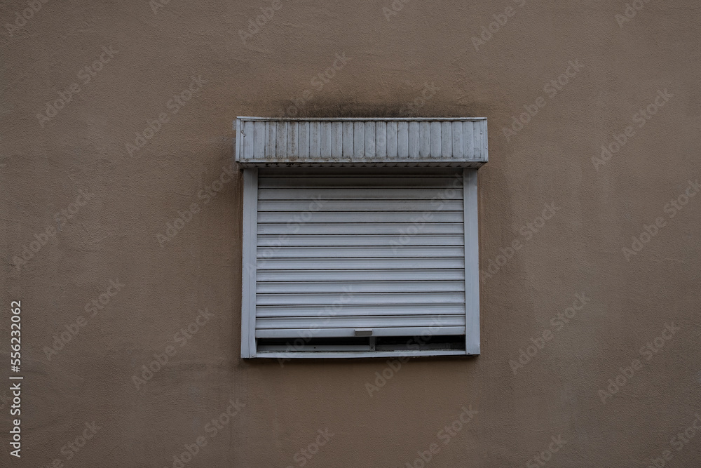 Fototapeta premium brown wall in the middle with a window covered with white blinds