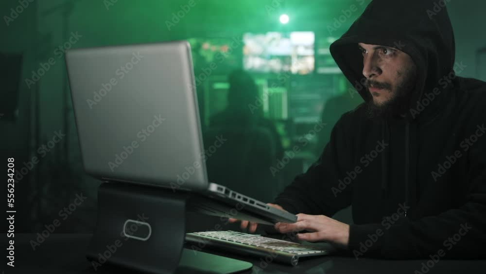 Hooded Hacker working in dark hidden basement, attacking Government Data Servers and infecting system with Virus Hooded Hacker working in dark hidden basement, attacking Government Data Servers and infecting system with Virus