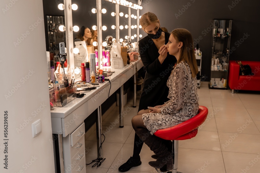 Make-up artist working with brush on model eyes Close up of applying make up on young girl,semi profile, professional make up in beauty studio Make-up artist working with brush on model eyes Close up of applying make up on young girl,semi profile, professional make up in beauty studio