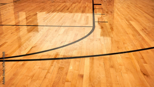 Interior of empty modern basketball indoor sport court, semigloss coating wooden floor, artificial lights reflected
