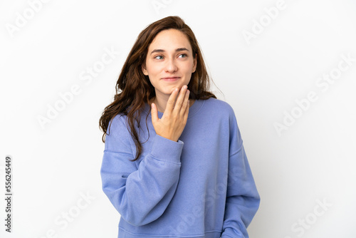Young caucasian woman isolated on white background looking up while smiling © luismolinero