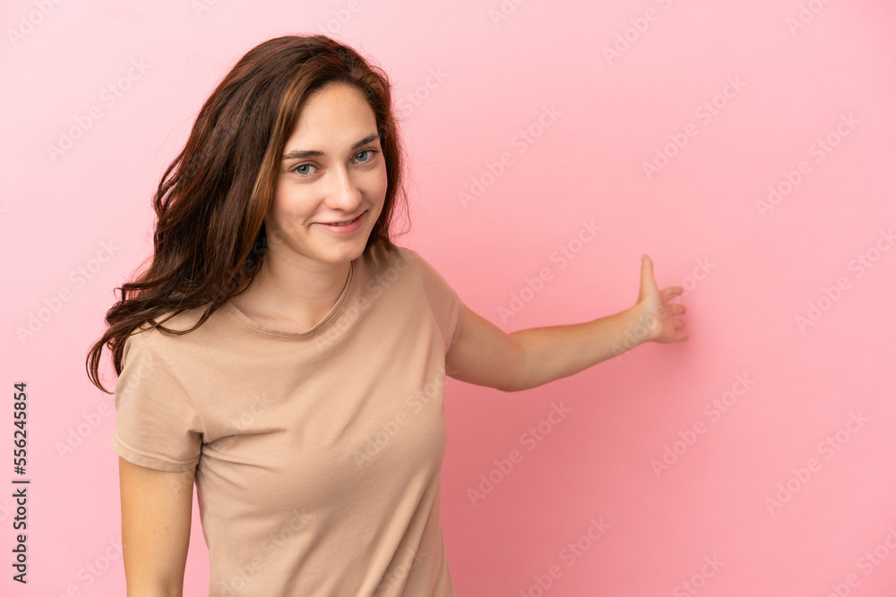 Young caucasian woman isolated on pink background extending hands to the side for inviting to come Young caucasian woman isolated on pink background extending hands to the side for inviting to come